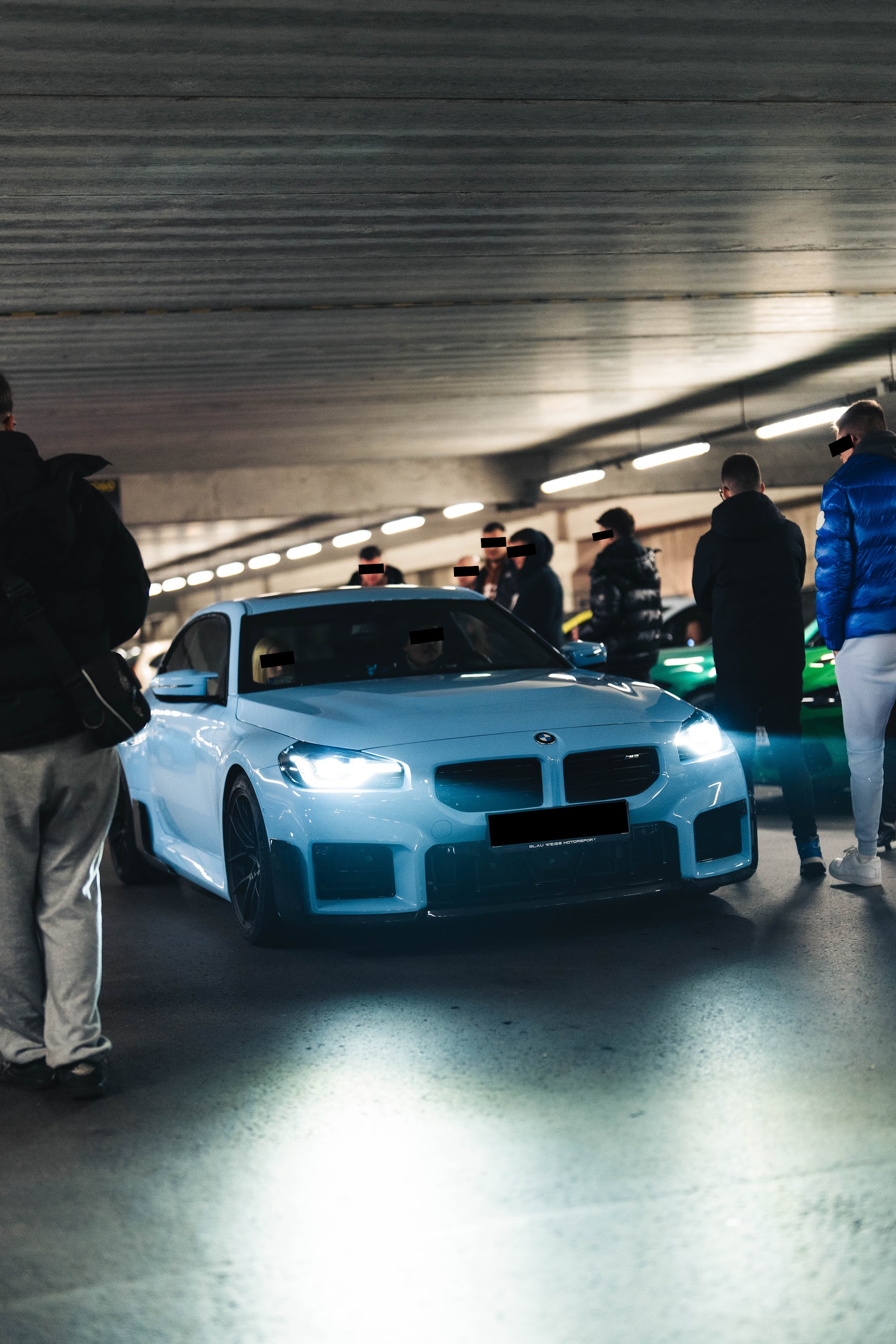 Világoskék sportlimuzin és résztvevők egy NightDrive eseményen
